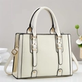 Detailed close-up of cream handbag featuring contrasting black edges and gold hardware - Off White