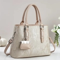 Elegante borsa a mano beige testurizzata con manico curvo e mini ciondolo abbinato - Albicocca