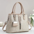 Borsa tote beige in ecopelle metallizzata con ciondolo a nappe e doppi manici - Albicocca