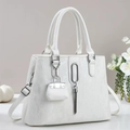 Dettaglio borsa a mano bianca in pelle goffrata con finiture argentate e nappina - Bianco