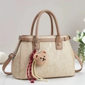Elegante champagnerfarbene Handtasche mit Perlglanzstruktur und Bärenanhänger - Khaki