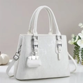 Détail d'un sac à main élégant en cuir PU blanc avec finitions argentées et pendentif - Blanc Cassé