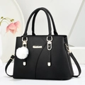Borsa tote nera in pelle martellata con logo oro, tracolla e ciondolo a pompon bianco - Nero