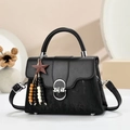 Detailed texture of black mixed material handbag with silver hardware and star tassel - Black