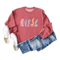 Flat lay of a dark red nurse coffee scrubs sweatshirt with denim jeans and sneakers - Red (White Letters)