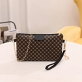 Retro monogram crossbody chain bag in black and brown with golden hardware on a white table - Patterned Black