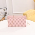 Pink crossbody bag with geometric pattern and gold chain strap on a white table - Pink
