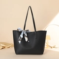 Bolso tote negro clásico con pañuelo de seda estampado sobre elegante fondo beige - Patrón de lichi negro