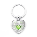 Détail macro du porte-clés en forme de cœur avec pierre verte et ailes d'ange - Coeur Vert