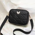 Black quilted crossbody bag with white butterfly metal detail and adjustable strap - Black