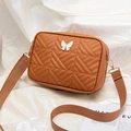 Compact brown quilted crossbody bag with butterfly hardware and woven shoulder strap - Brown