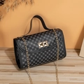 Detail of black embroidered crossbody bag with gold chain and floral patterns on wood desk - Vintage Monogram Black