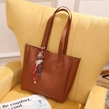 Braune Shopper-Tasche aus Kunstleder mit Seidenschal auf gelbem Sofa, große Damentasche - Braun