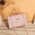 Pink quilted crossbody bag with gold chain strap and metal turn-lock on wooden table - Pink