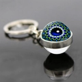 Macro shot of silver Eye of Horus keychain with mandala pattern and glass ball detail - Jy008522-6