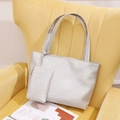 Silver woven texture tote bag set with matching pouch on a yellow velvet sofa - Silver