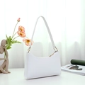 Minimalist white PU leather underarm bag with gold ring hardware in a soft light setting - White