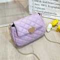 Detail of lavender quilted crossbody bag with golden heart lock on a minimal background - Purple