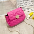 Detail of pink quilted crossbody bag featuring a golden heart buckle and chain strap - Rose Red