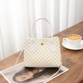 Detail view of white leather handbag with yellow retro prints and golden magnetic clasp - Pattern White