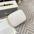 Beige quilted crossbody bag with golden chain strap on a textured gray background - Off White