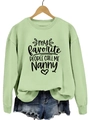 Détail d'un sweat vert clair avec imprimé cœur Nanny sur un cintre en bois - Sweat-shirt Vert Olive (Police Noire)