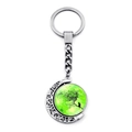 Close-up of rotating metal keychain with tree and cat silhouette under a green moon - Bright Green Moon Cat (JY008594-5)