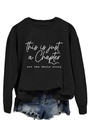Detail of black crewneck sweatshirt with 'This is just a chapter' white printed text - S / White Font / Black