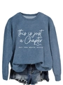 Close-up of fog blue sweatshirt featuring This is just a Chapter white printed text - S / White Font / Blue