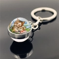 Detailed view of glass dome keychain showing two sleeping cats illustration with silver ring - Orange Cats Hugging Illustration(XSWX2233-11)