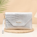 Pochette argento con trama a coccodrillo e logo dorato su sfondo stile vacanza - Argento