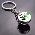 Close-up of a silver keychain with a round panda and bamboo glass dome pendant - Panda with Green Bamboo Background (JY008711-7)