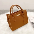 Chic caramel brown pebbled leather tote bag with dual handles and gold metal hardware - Brown