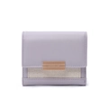 Detail of lavender trifold wallet with pebble leather texture and gold metal plaque - Purple
