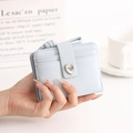 Detail of light blue folding wallet featuring heart buckle and engraved brand logo - Blue