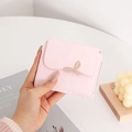 Detail of light pink small PU leather wallet featuring a gold leaf buckle and quilting - Pink