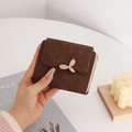 Detail of dark brown PU leather wallet featuring leaf buckle and vertical stitching decor - Coffee
