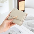 Nahaufnahme der minimalistischen dreifach gefalteten Brieftasche mit Blattverschluss - Aprikose
