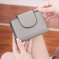 Primer plano de una mini cartera gris de cuero texturizado sostenida para ver el tamaño - Gris