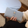 Detail of light blue leather long wallet featuring leaf embroidery and petal metal buckle - Sky Blue