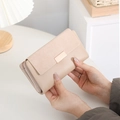 Dettaglio di un portafoglio lungo beige con patta opaca e chiusura in metallo dorato - Albicocca