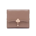 Close-up of small mocha wallet featuring wave edges and a golden cloud-shaped metal clasp - Brown