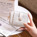 Close-up of a floral faux leather mini wallet with gold zipper and snap button - Gray