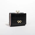 Short black glossy wallet with pearl clasp and golden bow detail on white background - Black