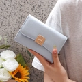 Short minimalist light blue leather folding wallet for women held by model in hand - Sky Blue