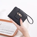 Close-up of black lychee grain wallet featuring a gold bow clasp and hand strap - Black