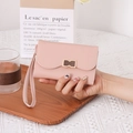 Close-up of pink leather wallet featuring a wavy flap design and metal clasp detailing - Pink