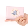 Close-up of a pink tri-fold wallet featuring a cute cartoon cat and heart pattern - Pink