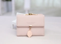 Détail d'un portefeuille rose en cuir PU avec fermoir doré vintage et pendentif feuille - Rose