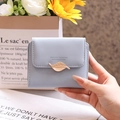 Close-up of short PU leather wallet featuring a golden leaf clasp and brand engraving - Blue